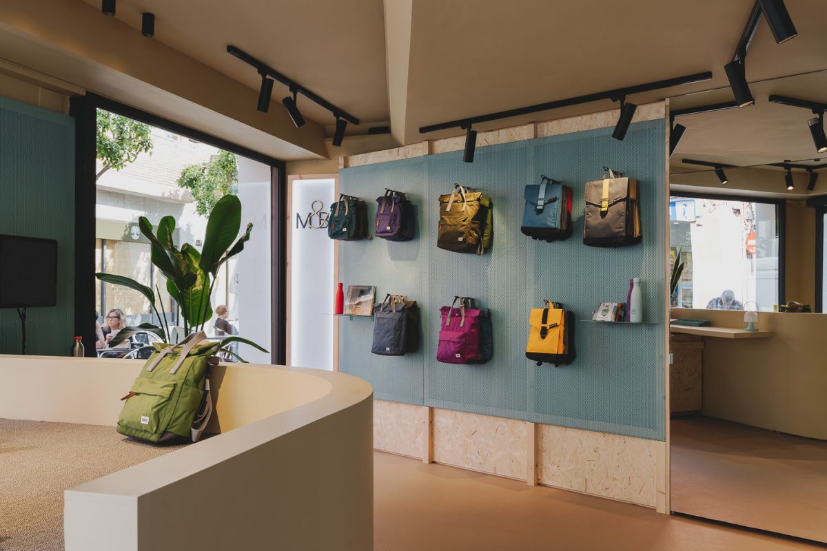 the interior of a store with a lot of bags hanging on the wall.